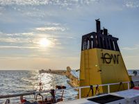 Photo of the evening sun over the Baltic Sea behind the IOW research vessel